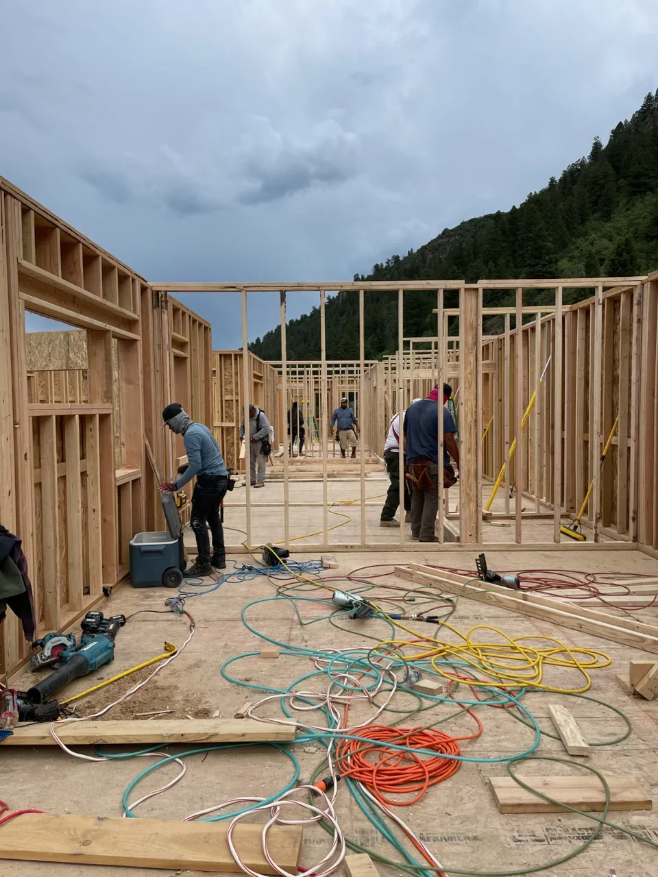 Wood framing construction site with multiple residential structures, dimensional lumber walls and roof trusses