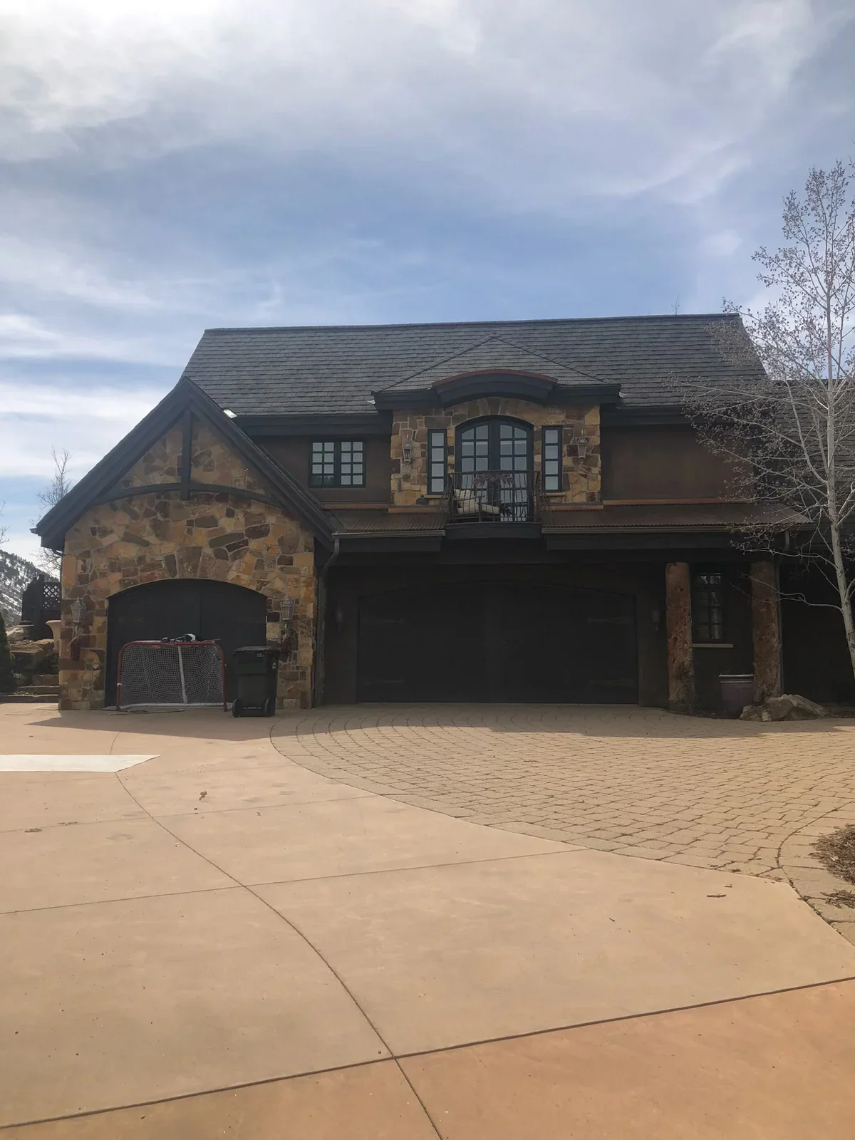 Stone veneer and stucco residential addition with two-car garage and slate roof