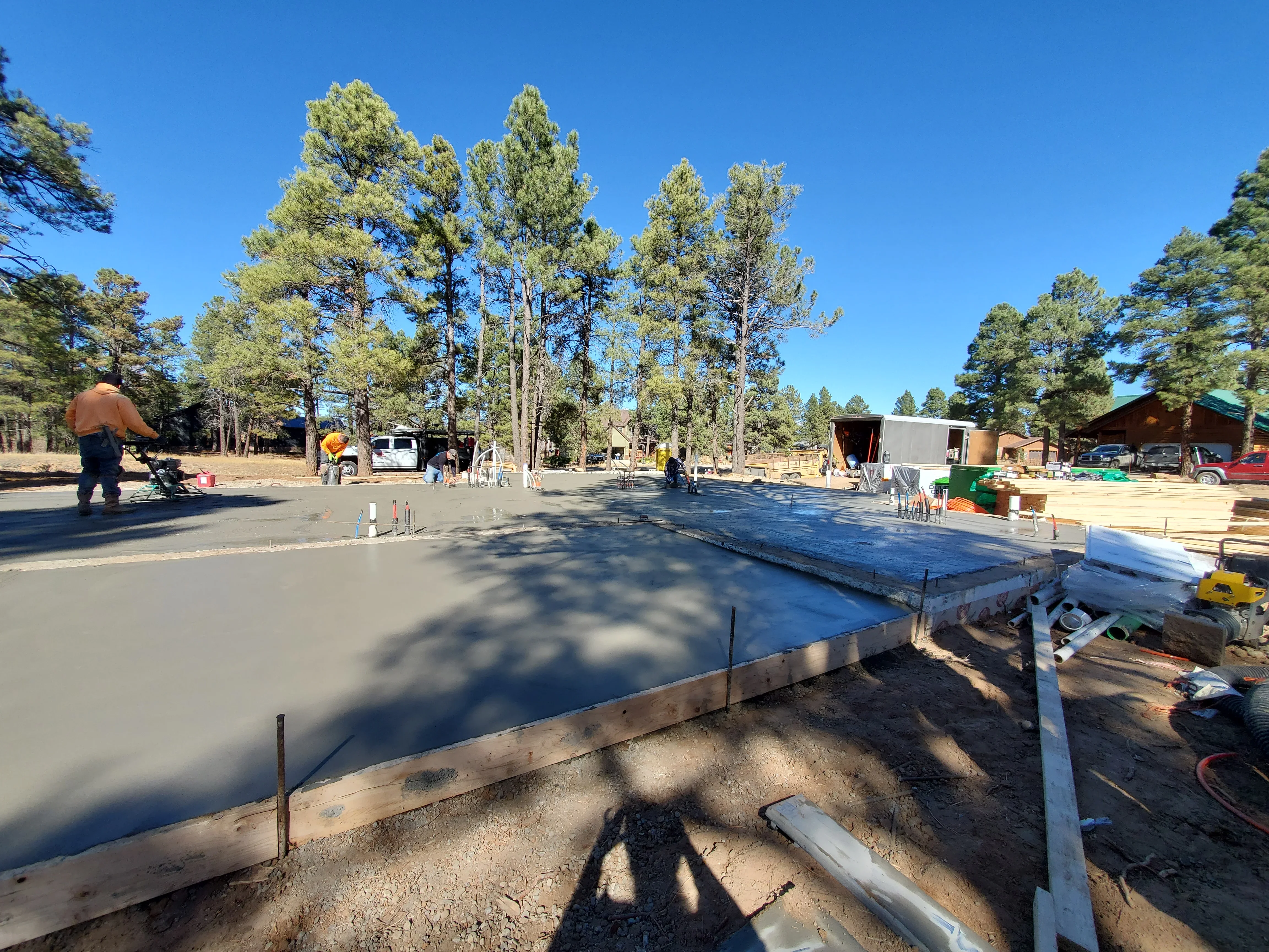 Concrete foundation pour with wooden forms and blue vapor barrier on prepared ground