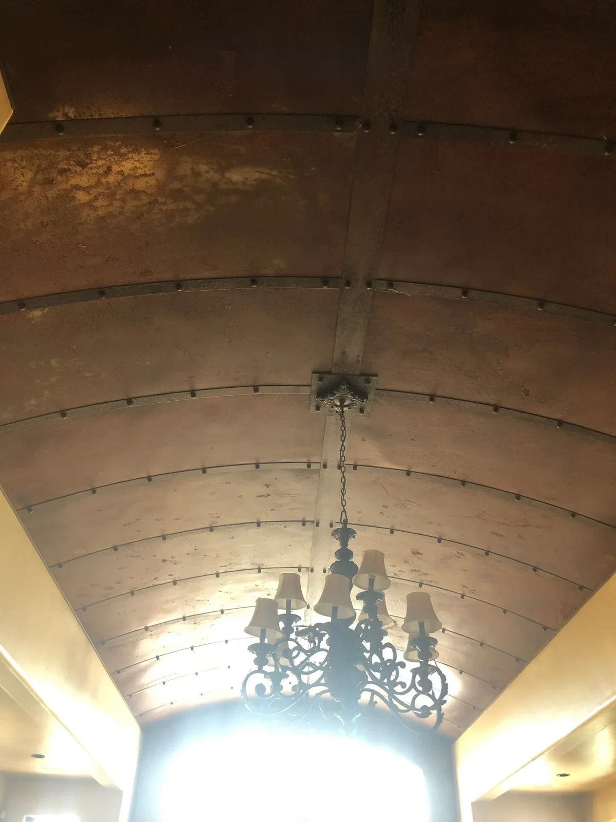 Barrel vault ceiling with curved metal ribs, drywall finish, recessed lighting, and hanging chandelier